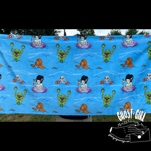 Blue towel with monsters havinga pool party