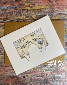Thank you card: ouija board reads "thank you" with a ghost moving the planchette